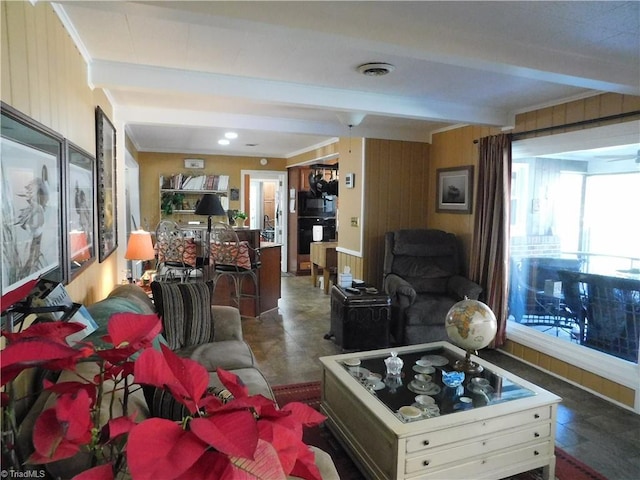 living room with crown molding, wooden walls, and beam ceiling