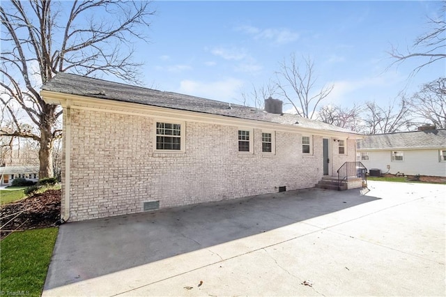 3027 Kinnamon Rd, Winston-Salem, NC 27104 - back of property featuring crawl space, brick siding, a patio, and a chimney