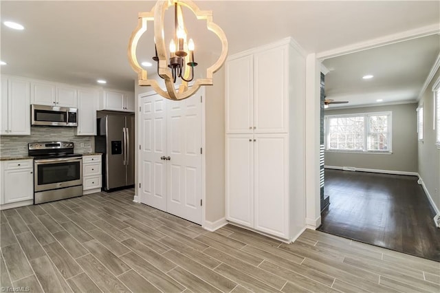 3027 Kinnamon Rd, Winston-Salem, NC 27104 - kitchen featuring appliances with stainless steel finishes, a chandelier, baseboards, light wood finished floors, and recessed lighting