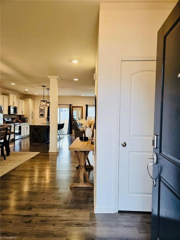 foyer featuring dark hardwood / wood-style flooring and ornate columns