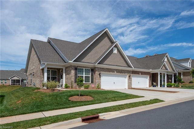 410 Mountain Grove Ln, Kernersville, NC 27284 - craftsman-style house with brick siding, a garage, concrete driveway, a front lawn, and roof with shingles