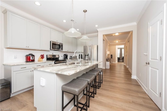 410 Mountain Grove Ln, Kernersville, NC 27284 - kitchen featuring appliances with stainless steel finishes, a sink, crown molding, a kitchen breakfast bar, and light stone countertops