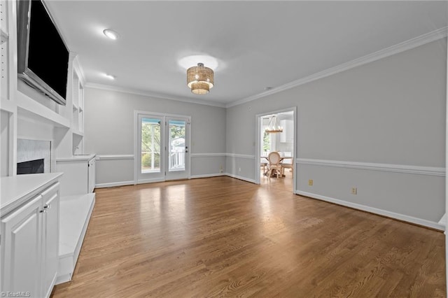 1203 Westminster Dr, Greensboro, NC 27410 - unfurnished living room with ornamental molding, light wood-style flooring, a fireplace, and a chandelier