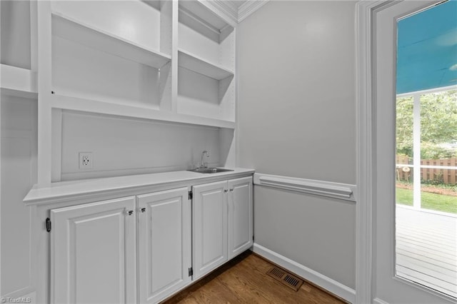 1203 Westminster Dr, Greensboro, NC 27410 - indoor wet bar featuring dark wood-type flooring and crown molding