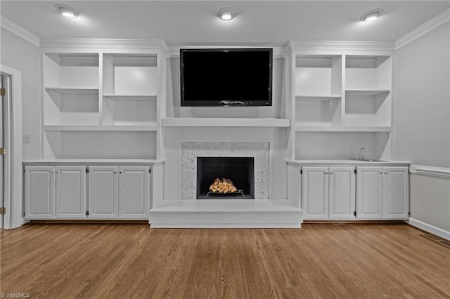 1203 Westminster Dr, Greensboro, NC 27410 - unfurnished living room with ornamental molding, wood finished floors, built in features, wet bar, and a premium fireplace