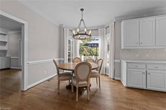 1203 Westminster Dr, Greensboro, NC 27410 - dining room featuring a chandelier, crown molding, and dark wood-style flooring