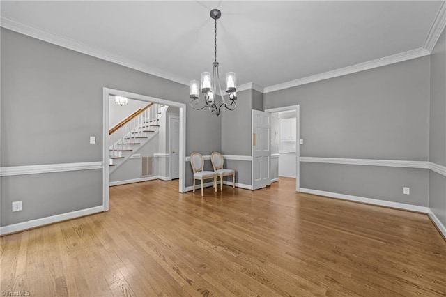 1203 Westminster Dr, Greensboro, NC 27410 - spare room with stairs, a chandelier, wood finished floors, and crown molding