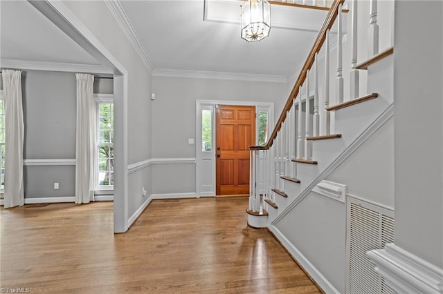 1203 Westminster Dr, Greensboro, NC 27410 - entrance foyer with stairway, wood finished floors, a chandelier, and crown molding