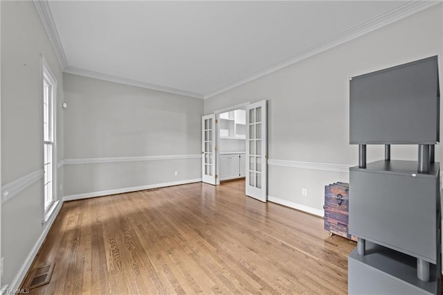 1203 Westminster Dr, Greensboro, NC 27410 - unfurnished living room featuring french doors, wood finished floors, and ornamental molding