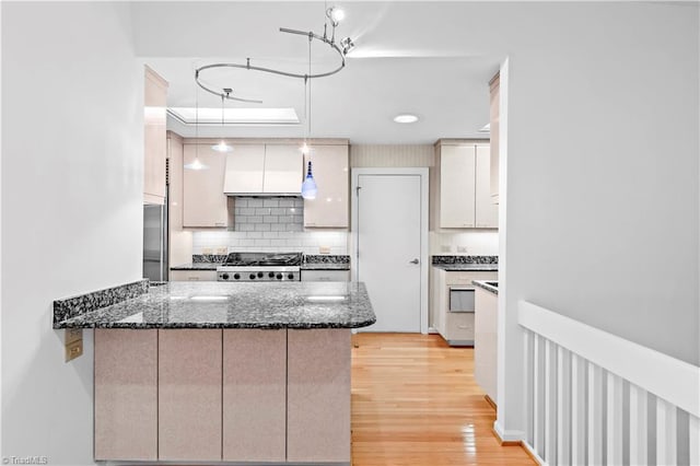 881 Brookleigh Ct, Winston-Salem, NC 27104 - kitchen with range, custom exhaust hood, light wood-type flooring, tasteful backsplash, and stainless steel built in fridge