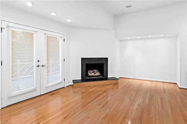 881 Brookleigh Ct, Winston-Salem, NC 27104 - unfurnished living room featuring a fireplace with raised hearth, wood finished floors, french doors, and baseboards