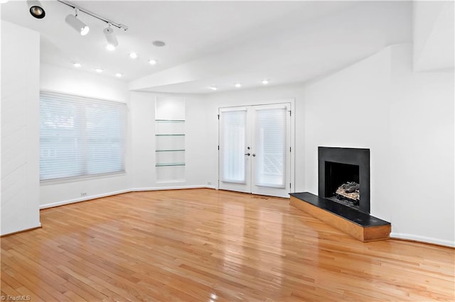 881 Brookleigh Ct, Winston-Salem, NC 27104 - unfurnished living room featuring light wood finished floors, built in shelves, baseboards, a fireplace with raised hearth, and recessed lighting