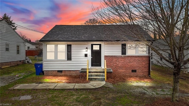 bungalow-style home featuring crawl space, a shingled roof, and brick siding