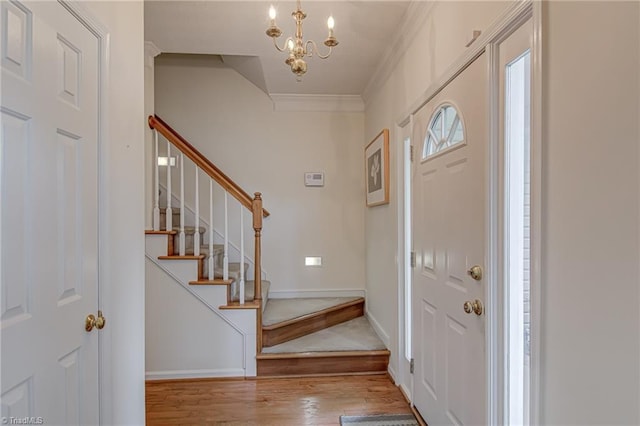 4317 Bradbury Way, High Point, NC 27265 - entryway featuring wood finished floors, a chandelier, stairway, and crown molding