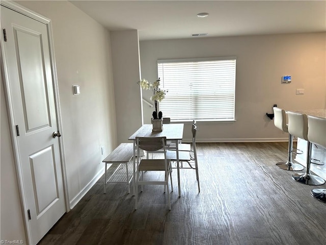 dining space featuring visible vents, baseboards, and dark wood-style floors