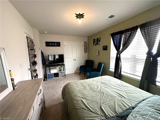 carpeted bedroom with visible vents and a closet