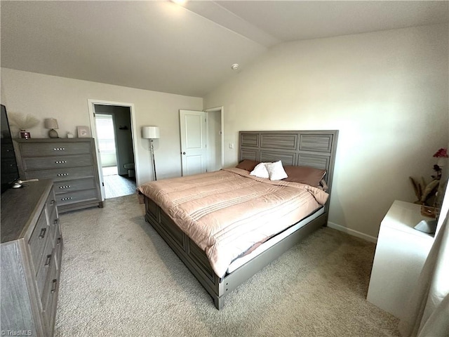 bedroom with baseboards, light colored carpet, and vaulted ceiling