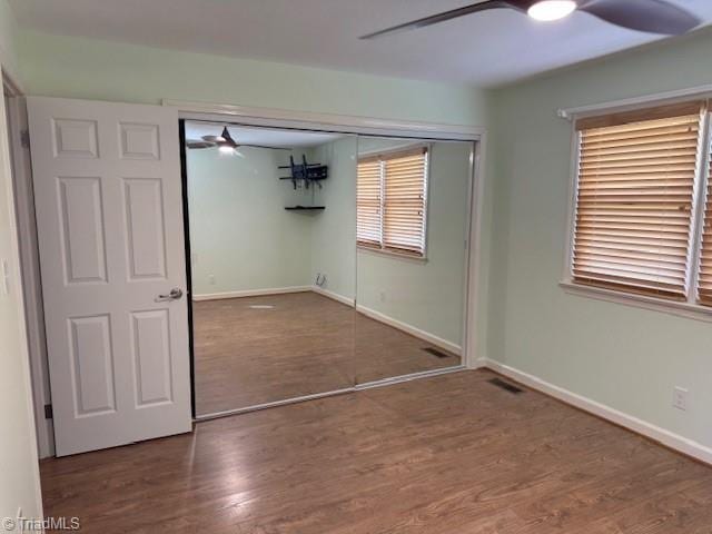 unfurnished bedroom featuring a closet, baseboards, and wood finished floors