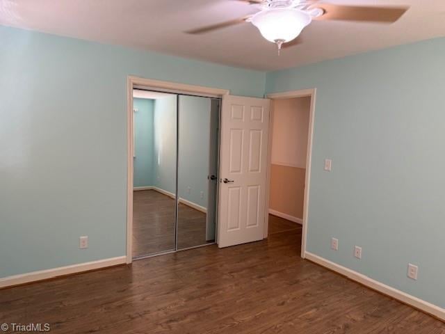 unfurnished bedroom featuring a closet, ceiling fan, baseboards, and wood finished floors