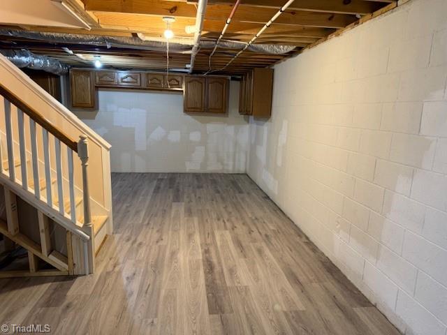 unfinished below grade area featuring light wood finished floors and stairs