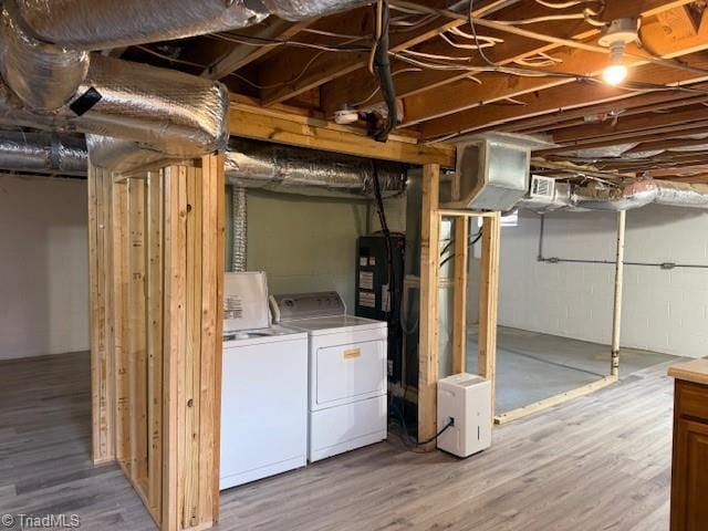 unfinished basement featuring wood finished floors and separate washer and dryer