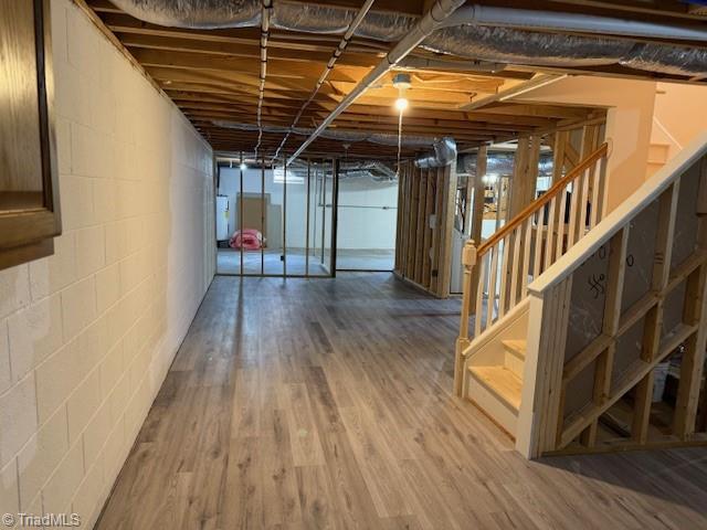 unfinished below grade area featuring wood finished floors and stairs