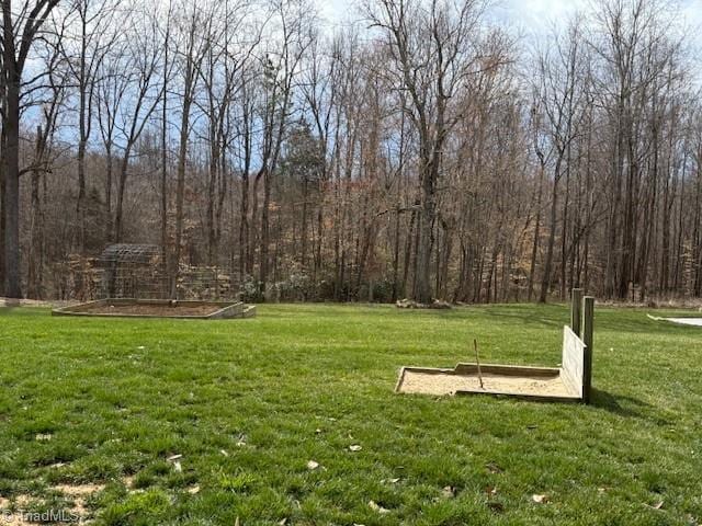 view of community featuring a forest view and a lawn