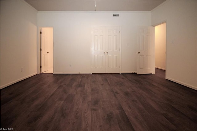 39 Fountain Manor Dr Unit A, Greensboro, NC 27405 - unfurnished bedroom featuring ornamental molding, dark wood-style flooring, baseboards, and a closet