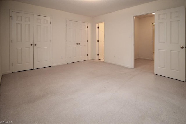 39 Fountain Manor Dr Unit A, Greensboro, NC 27405 - unfurnished bedroom featuring multiple closets, light colored carpet, and baseboards