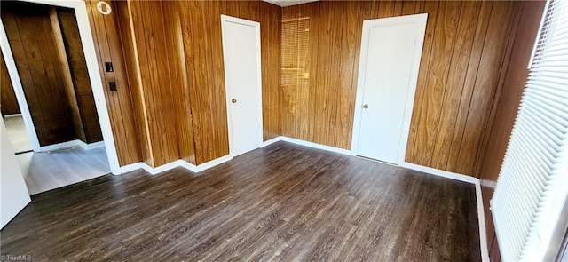 unfurnished bedroom featuring dark hardwood / wood-style floors, wood walls, and a closet