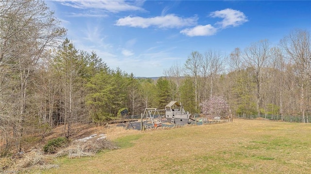 view of yard featuring fence and a forest view