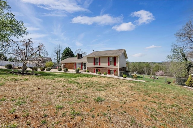 tri-level home with a front lawn, fence, and a chimney