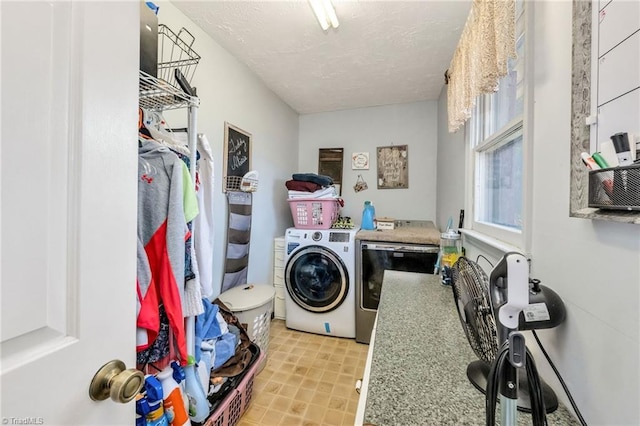 laundry area featuring washer and clothes dryer, laundry area, and a textured ceiling