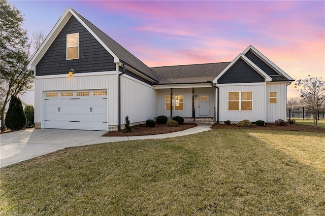 view of front of property with a garage and a lawn