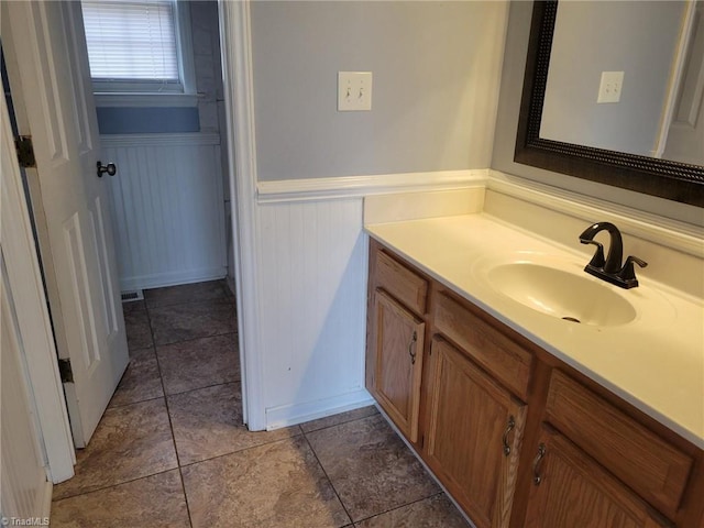 bathroom with vanity, tile patterned floors, and wainscoting