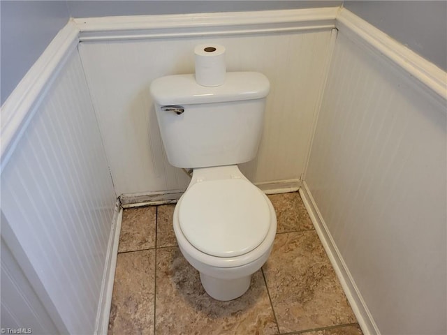 bathroom featuring a wainscoted wall and toilet