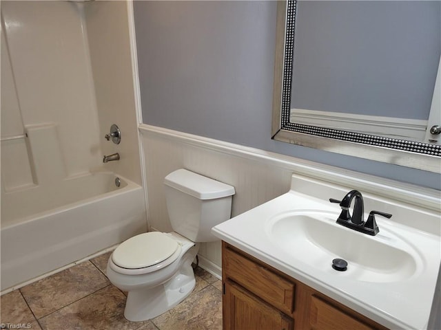 full bath featuring a wainscoted wall, toilet, vanity, and shower / tub combination