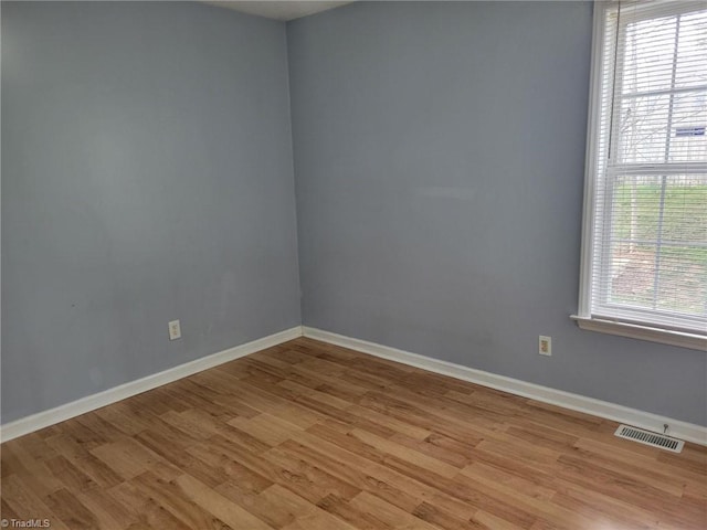 spare room with visible vents, baseboards, and light wood finished floors