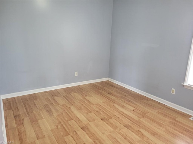 empty room with baseboards and light wood finished floors