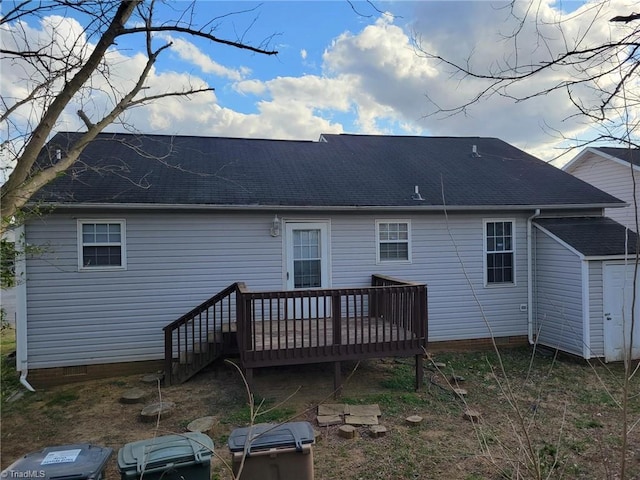 back of property with a shingled roof, an outdoor structure, crawl space, a deck, and a storage shed