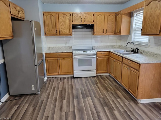 kitchen featuring dark wood-style floors, white electric stove, freestanding refrigerator, a sink, and under cabinet range hood