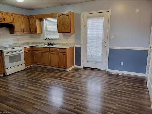 kitchen with white range with electric cooktop, dark wood finished floors, under cabinet range hood, and a sink