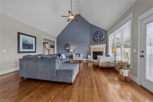 601 Rachel Smothers Dr, Greensboro, NC 27455 - living area with wood finished floors, a glass covered fireplace, ceiling fan, baseboards, and high vaulted ceiling