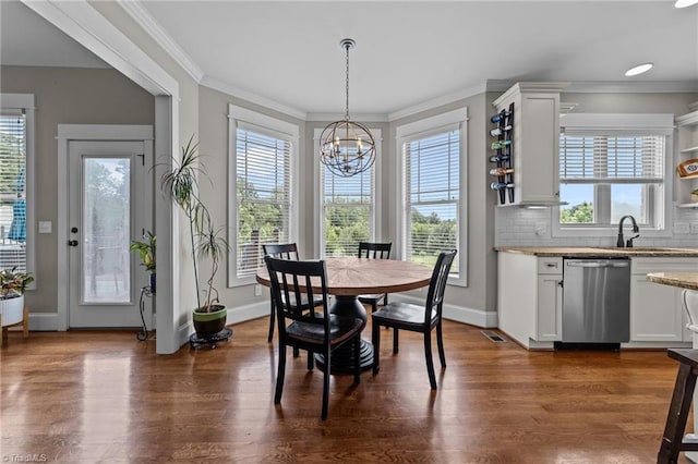 601 Rachel Smothers Dr, Greensboro, NC 27455 - dining area with healthy amount of natural light, a chandelier, crown molding, and dark wood finished floors