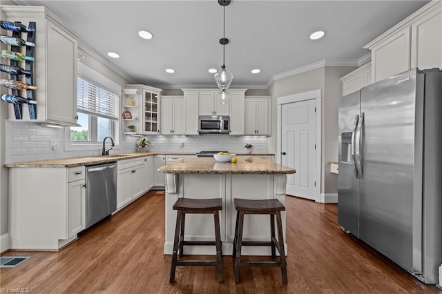 601 Rachel Smothers Dr, Greensboro, NC 27455 - kitchen featuring stainless steel appliances, white cabinetry, a center island, ornamental molding, and a sink