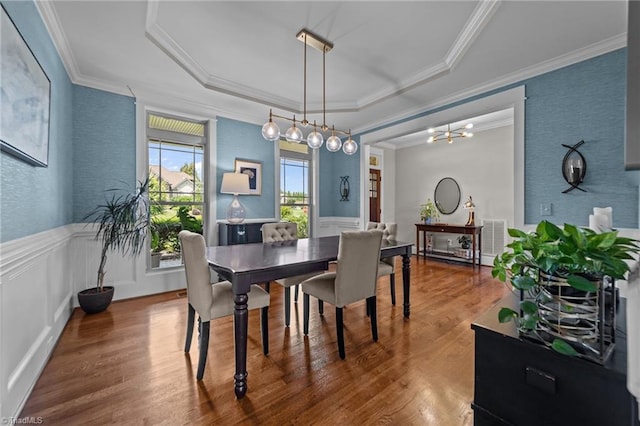 601 Rachel Smothers Dr, Greensboro, NC 27455 - dining room featuring a tray ceiling, wood finished floors, crown molding, wainscoting, and a chandelier