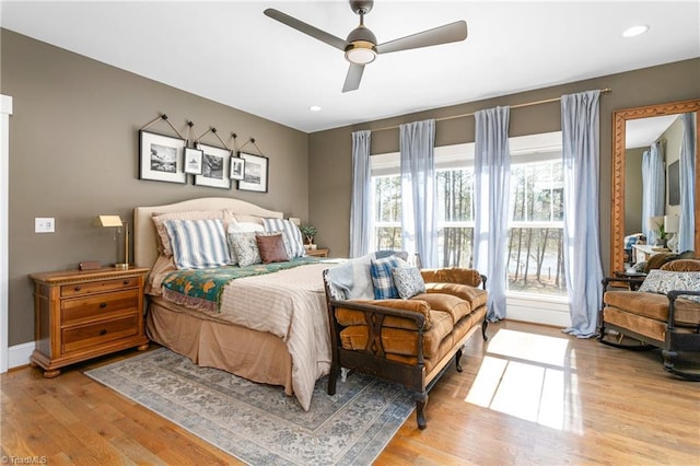 bedroom featuring baseboards, a ceiling fan, and light wood-style floors