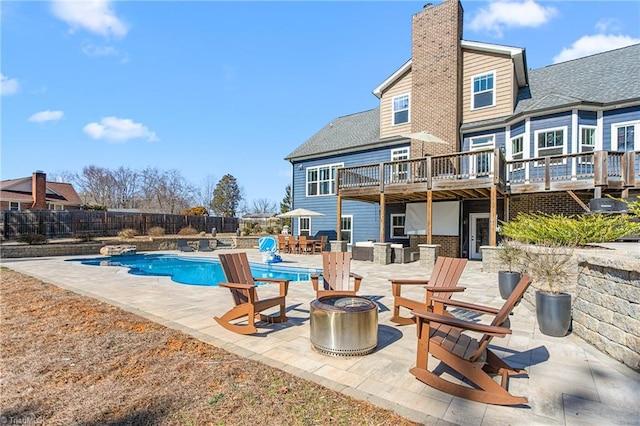 exterior space featuring a fenced in pool, a patio, fence, a fire pit, and a wooden deck