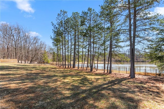 view of yard featuring a water view and fence