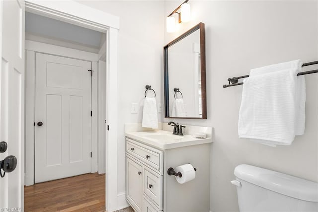 bathroom featuring toilet, wood finished floors, and vanity